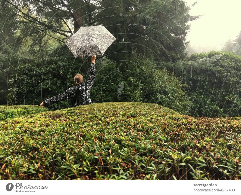 [HH unnamed road] Something's up.... Park Rain Umbrellas & Shades Woman bush Hedge Green Garden Hop Joy Wet Rain jacket Exterior shot Bad weather Nature