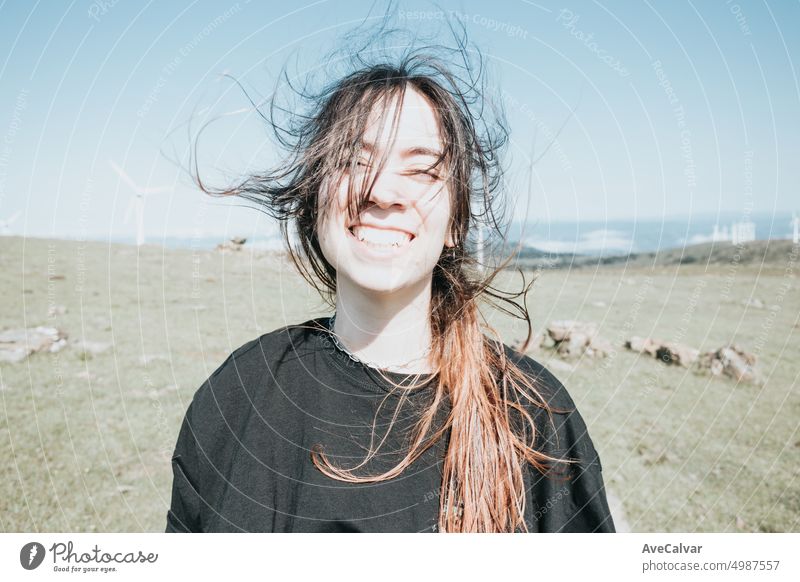 Young carefree woman with the hair blowing on the meadow. portrait confident content joyful lovely happiness people smiling charming happy young comfortable