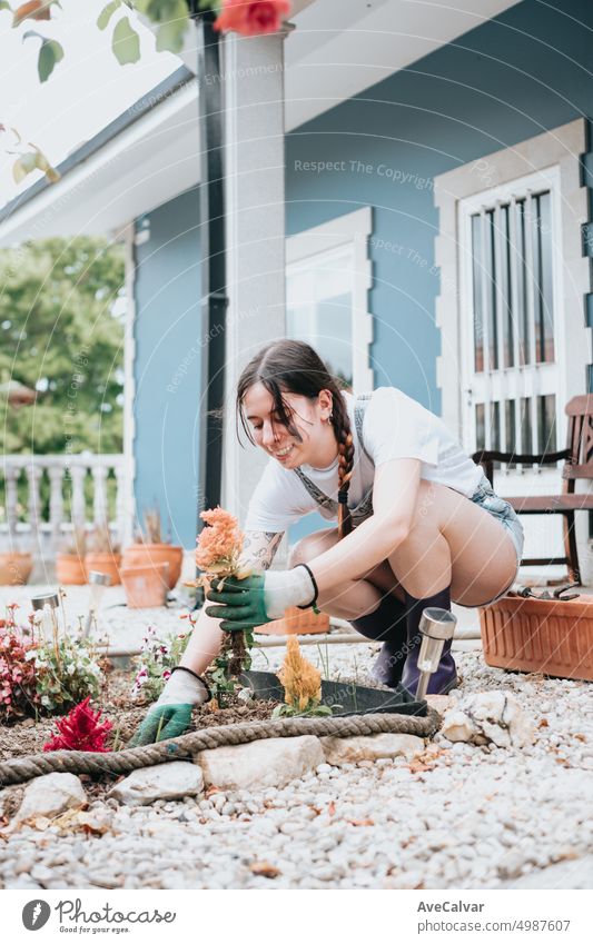Young woman planting new flowers on her garden during a sunny day. Smiling happy and enthusiast indoor hobby person growth copy space gardening business care