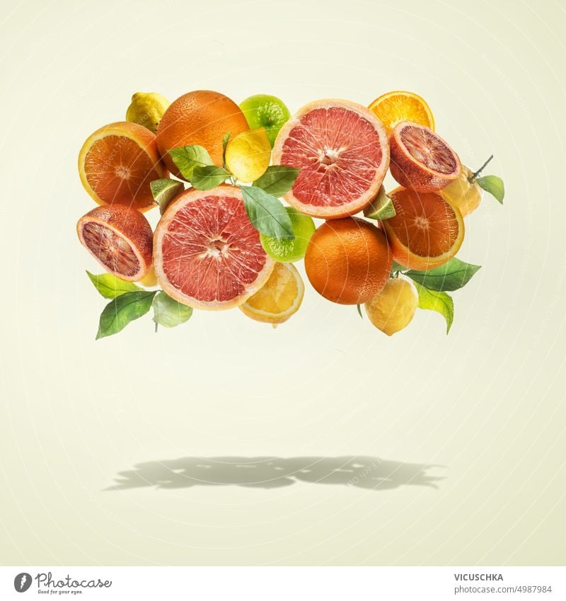 Group of flying various citrus fruits with green leaves at light yellow background group shadow healthy lifestyle food levitation frame grapefruit lime vitamins