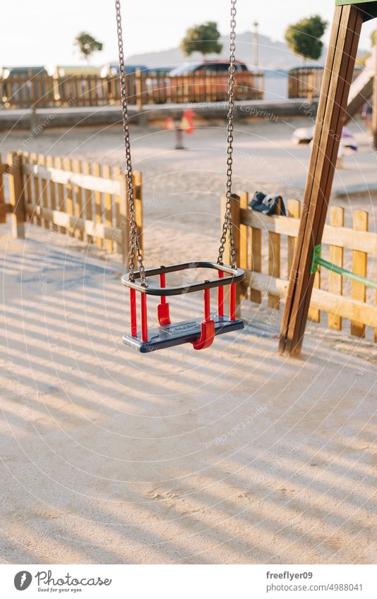 Detail of a toddler swing on a kids playground empty nobody copy space plastic safe danger quiet children set colourful object loneliness thing still autumn
