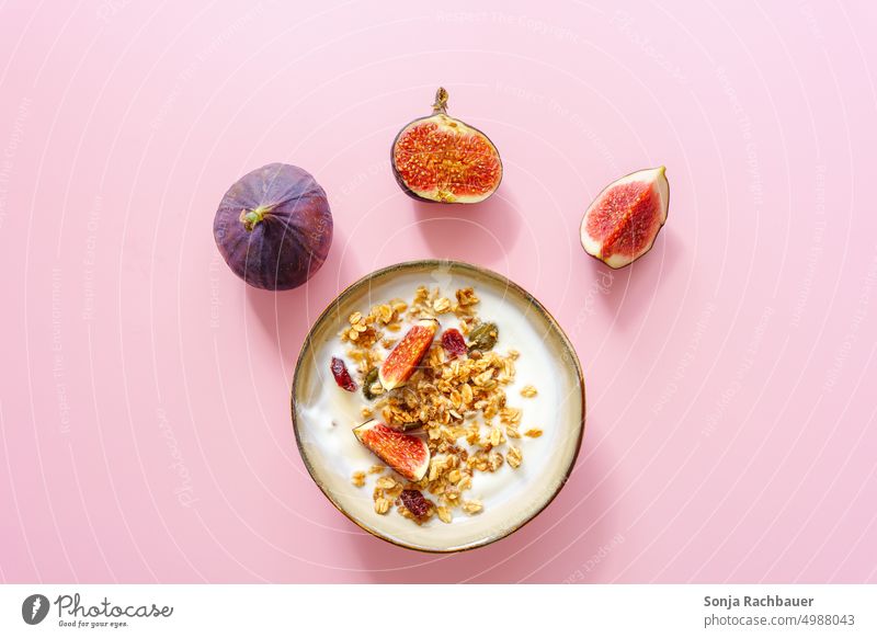 A bowl of yogurt, granola and fresh figs on a pink background. Breakfast. Cereal Fig Yoghurt Modern Food photograph Healthy Diet cute Nutrition Fresh Vitamin
