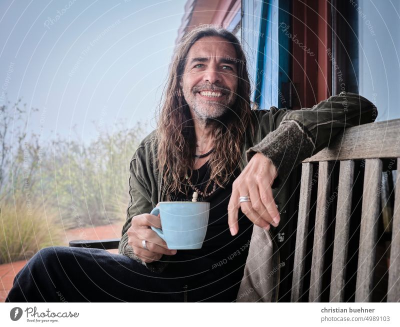 men portrait with cup Man long hairs Long-haired Hippie Cup Tea cup coffee cup coffee break kind Laughter cheerful laughing cloudy Rain Nature Wooden bench