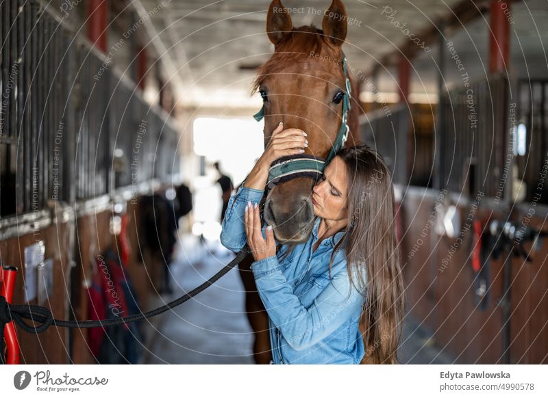 Woman taking care of her horse in stable Horse woman Ranch Saddle Stable One Person People Adult Barn animals Rural Scene Animal Trainer farm hobby