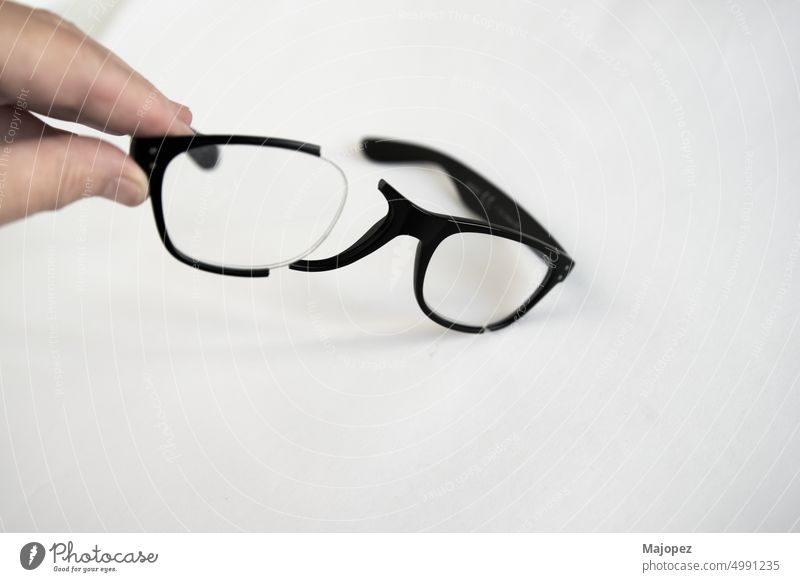 Caucasian human hand holding broken glasses frame. view wear design see read spectacles plastic eyesight style modern optical lens fashion vision object