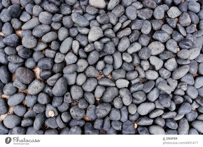 Close up of rounded grey river rocks smooth textured surface material wallpaper gray group rough hard zen simplicity polished pile colours harmony many