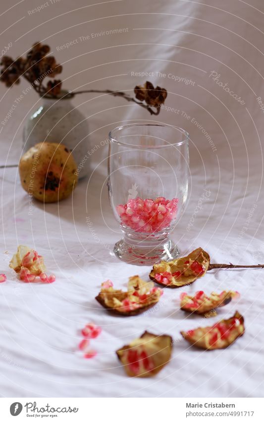 Vertical shot of pomegranate seeds on a drinking glass for making fresh fruit juice as refreshing summer drink Summer Pomegranate Refreshment Wellbeing
