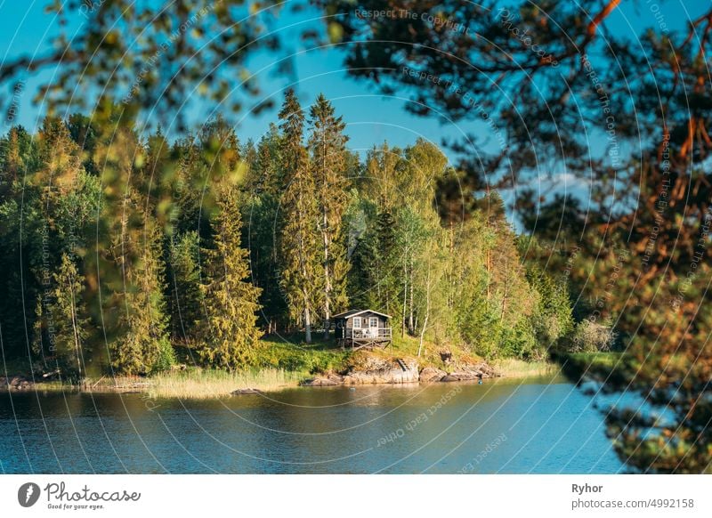 Sweden. Beautiful Swedish Wooden Log Cabin House On Rocky Island Coast In Summer Sunny Evening. Lake Or River Landscape apartment architecture bathhouse