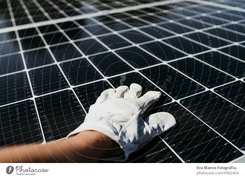 hand of mature Technician man touching solar panels on house roof for self consumption energy. Renewable energies and green energy concept drill technician