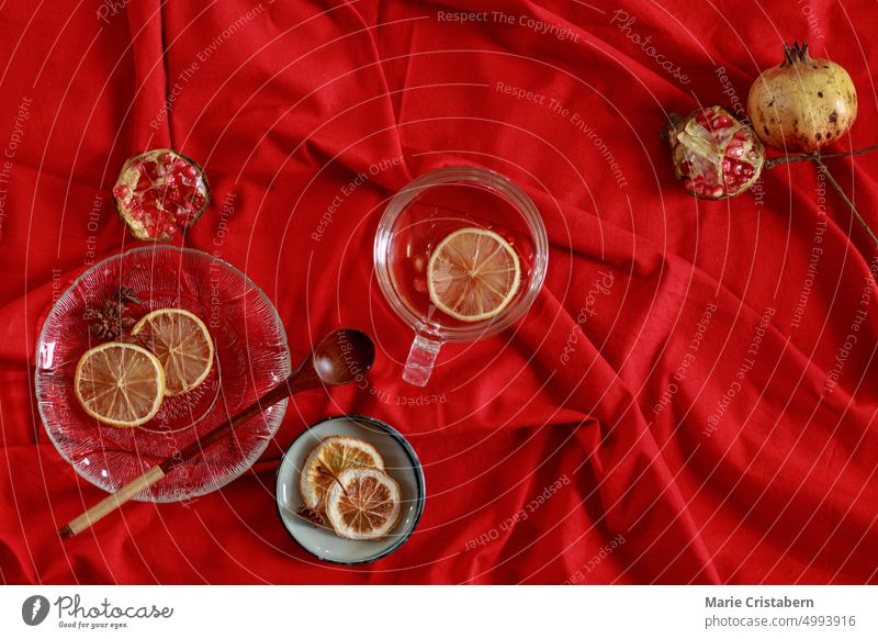 Top view of pomegranate fruits and lemon slices on a red background to make fresh juice that shows wellness and autumn aesthetic Design Red Autumn Pomegranate