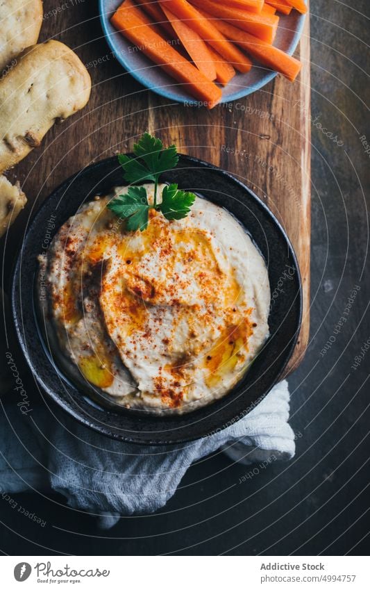 Homemade hummus ready to serve appetizer bowl bread carrot chickpea creamy dip food healthy homemade Hummus lunch oil olive oil paprika parsley snack tahini