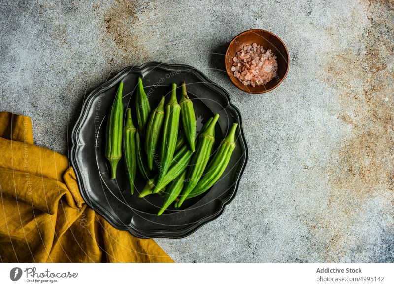 Raw okra and spices in the bowls background bamia bamya cook cooking cuisine food green healthy himalayan salt mix pepper cloth oil organic raw flat lay table