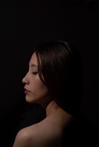 woman in profile with low lighting in a dark room Low-key Woman Feminine Shadow 18 - 30 years Human being Young woman Meditative Adults Shoulder Emotions