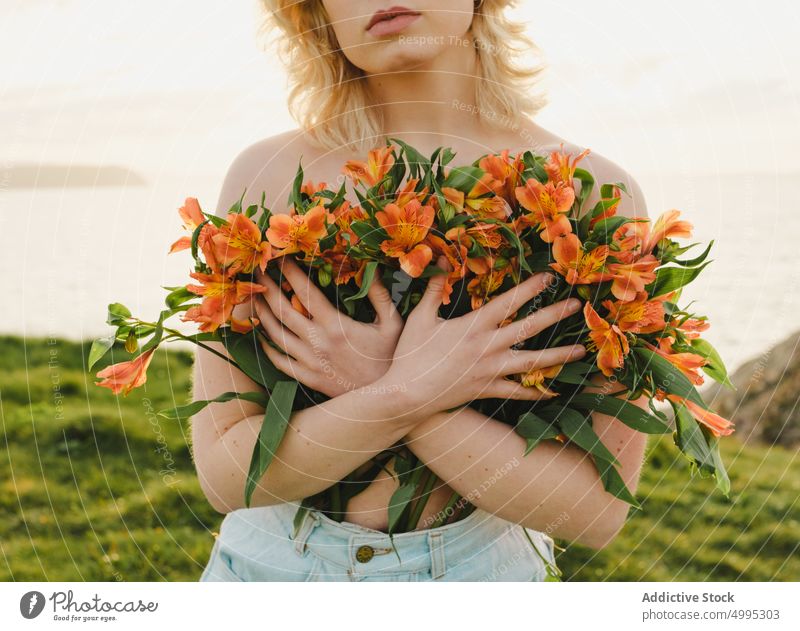 Woman with flowers near sea woman cover breast shore sunset topless nature evening summer aviles asturias spain female blond blossom season plant seaside water