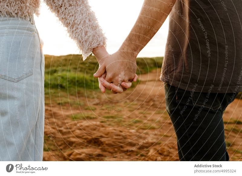 Crop couple holding hands in countryside sunset romantic love together relationship date weekend aviles asturias spain dusk twilight tender girlfriend boyfriend