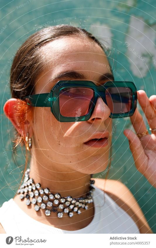 Self assured ethnic stylish lady looking at camera in sunlight woman sunglasses fashion style confident portrait model adjust self assured appearance accessory