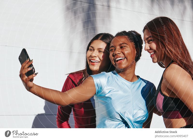 Delighted diverse young sportswomen taking selfie after training on street smile athlete friend together smartphone happy sporty cheerful workout multiracial