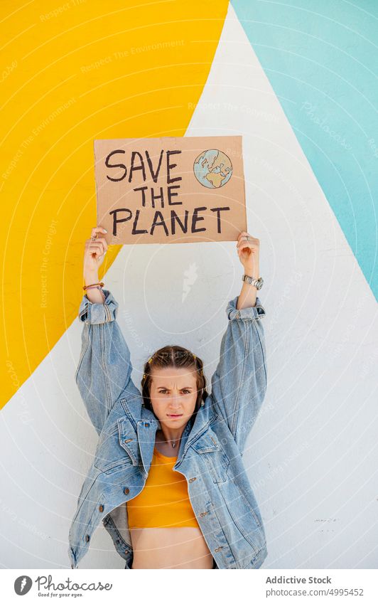 Young female showing ecological poster woman environment ecology save the planet bright protest event young casual denim banner wall placard demonstrate