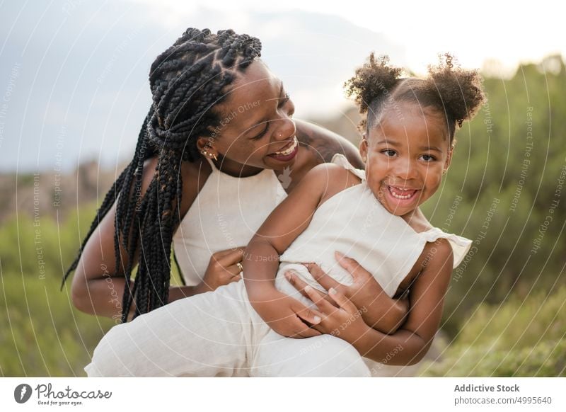 African American mom playing with daughter in nature mother countryside tickle summer weekend happy together playful woman girl black african american ethnic