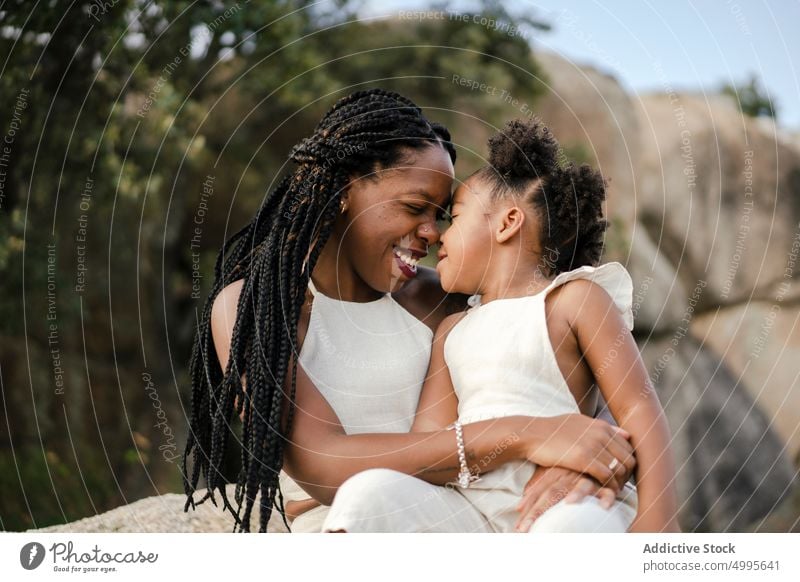 African American mom playing with daughter in nature mother countryside kiss summer weekend happy together playful woman girl black african american ethnic