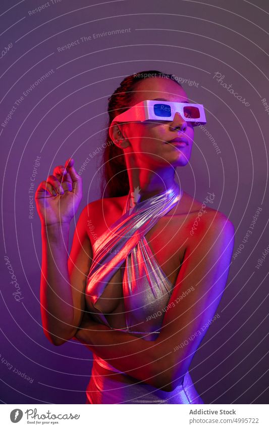 Attentive alluring young lady experiencing virtual reality in purple studio woman confident futuristic style vr innovation portrait cyberspace serious attentive
