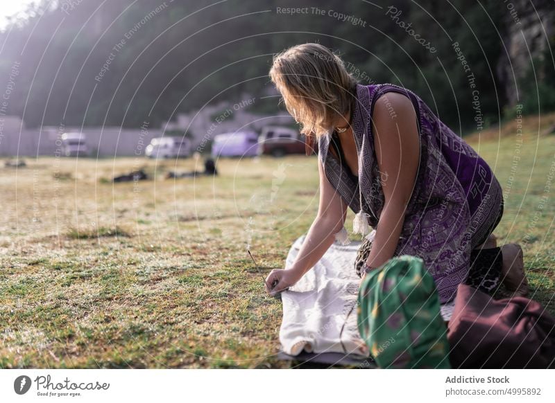 Anonymous woman putting incense stick on greasy lawn before meditation harmony meadow meditate recreation aromatherapy spirit shaman ritual prepare countryside