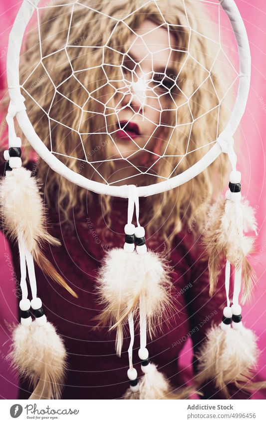 Woman with dream catcher in studio woman serene dreamy decorative feather blond peaceful eyes closed female style charming fantasy dress tender calm gentle show