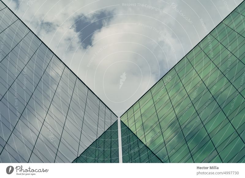 Facades of two identical buildings that form a green glass geometric structure in the city geommetry Architecture architectural photography