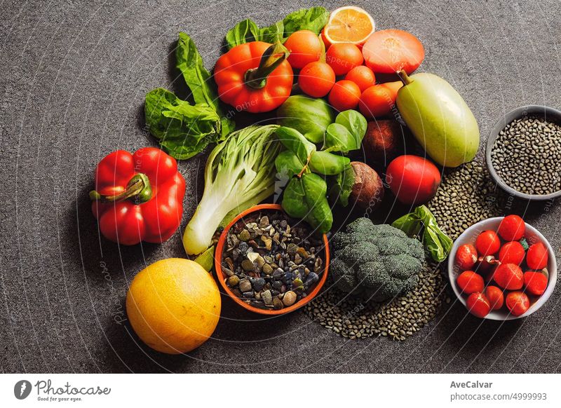 Fresh vegetables to cook healthy fresh food, condiment and cooking bowls on black stone slate background. Copy space of your text blackboard conceptual