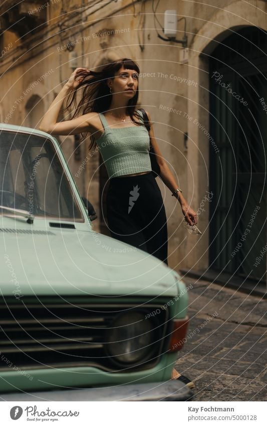 brunette lady wearing turquoise shirt standing next to turquoise car attractive beauty brunette hair caucasian cinematic city city life city street dress
