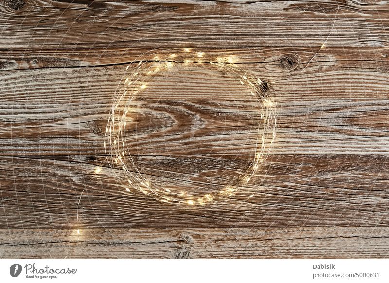 Circle frame made of lighting garland on wooden background circle festive composition christmas decoration flat lay top view copy space decorative traditional