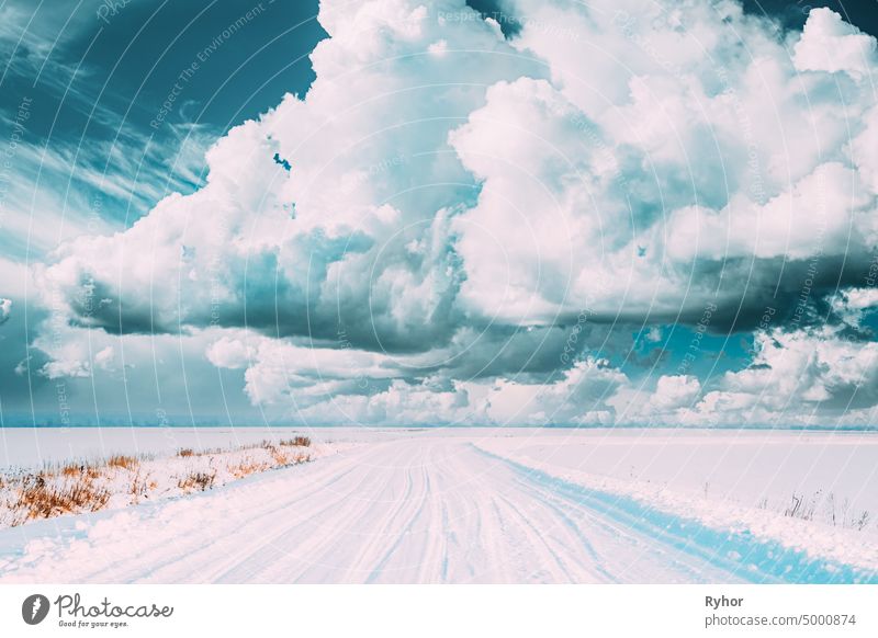 Snow-covered Countryside Road In Winter Cloudy Day. Altered Sky. altered sky beautiful blue cloud clouds cloudscape cold composite copy space country road