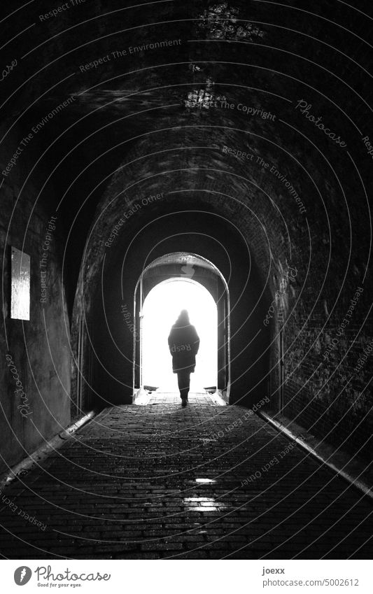Person walks at the end of a corridor throughTorbogn into the radiant light. Tunnel Light (Natural Phenomenon) Contrast Lanes & trails Belief Religion and faith