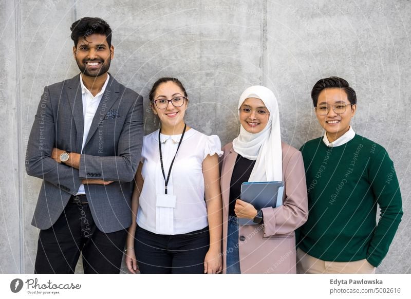 Shot of a small diverse group of businesspeople standing against a grey wall Multiracial Group team diversity teamwork muslim Multi-ethnic office real people