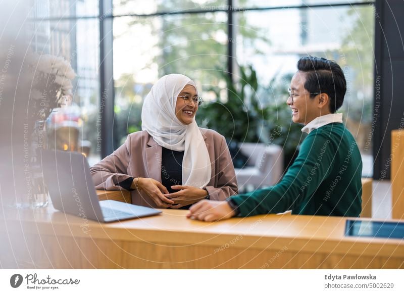 Young business couple using laptop in the office Multiracial Group team diversity teamwork muslim Multi-ethnic group real people young adult student positive