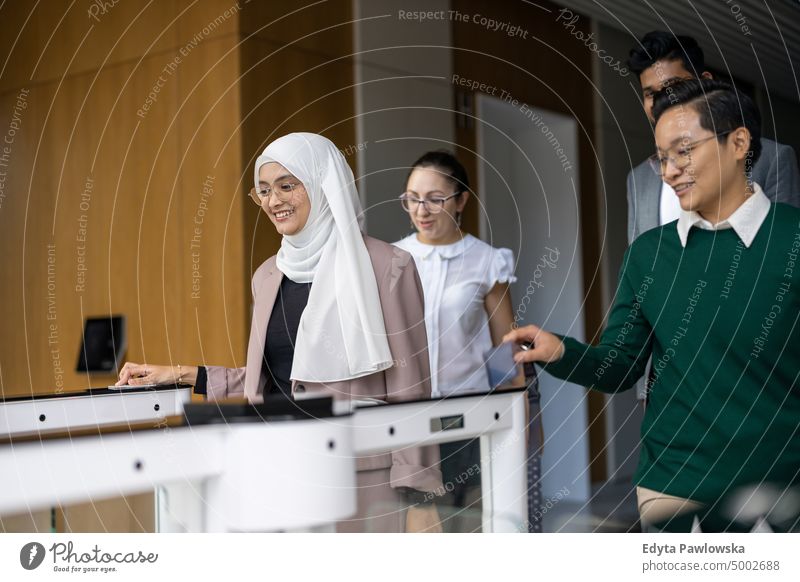 Young business people entering their workplace through security turnstiles Multiracial Group team diversity teamwork muslim Multi-ethnic group office
