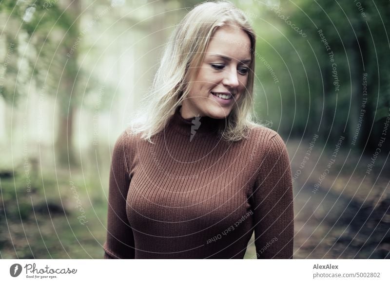 Young blonde woman with dimples stands in forest and smiles happily at camera Young woman Woman Blonde Feminine pretty fortunate Youth (Young adults) portrait