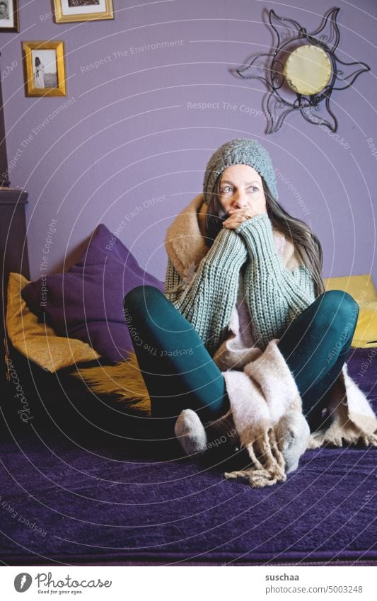 woman sits in woolen clothes at home on the sofa and freezes Woman Winter Cold Flat (apartment) Freeze Save heating costs inflation Energy crisis Heating