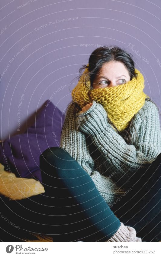 woman sits with wool scarf at home on the sofa and freezes Woman Winter Cold Flat (apartment) Freeze Save heating costs inflation Energy crisis Heating