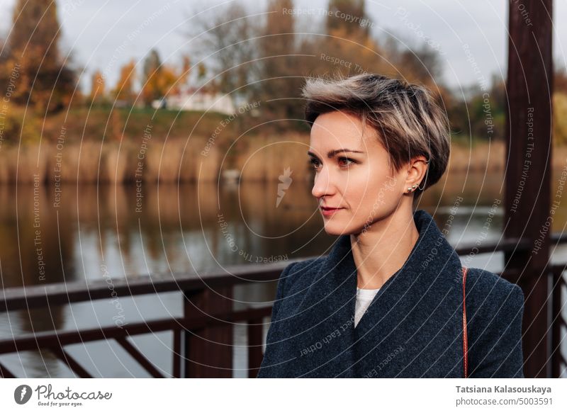 Woman look away against the backdrop of the river in autumn woman fall short-haired Lifestyle Confidence female adult Contemplation Watching 30-35 years harmony