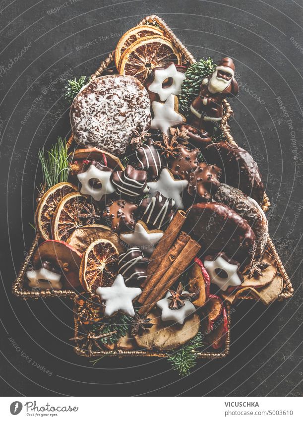 Christmas tree made with various pastry, cookies, gingerbread, chocolate and winter spices. Top view christmas tree top view rustic brown cinnamon bakery