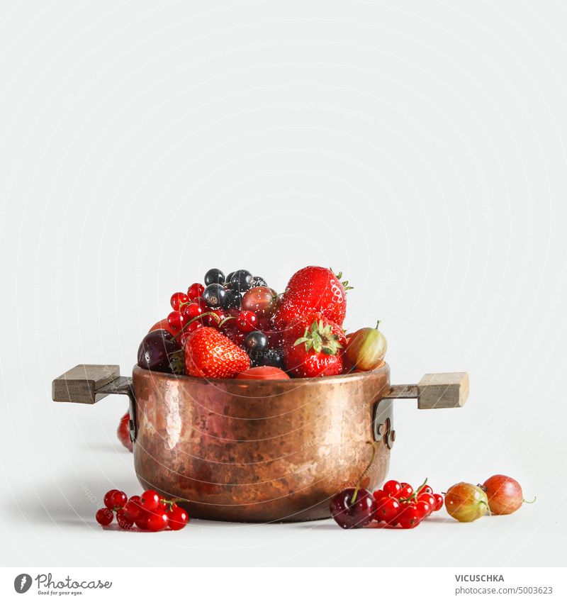 Copper cooking pot with fresh fruits and berries st white background copper pot vitamins season jam confiture preserve marmalade object ingredient food healthy