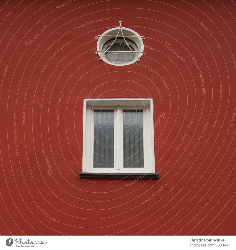 Detail of red plastered house with one round and one square window Window Facade red facade Ventilate Tilted window Rendered facade Window pane Window frame
