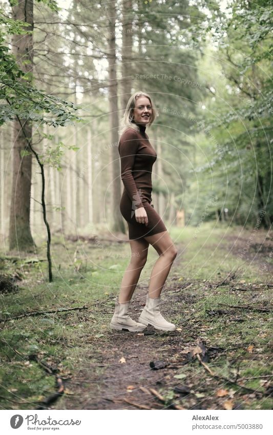 Young blonde woman walking on forest path and looking sideways at camera Young woman Woman Blonde Feminine pretty fortunate Youth (Young adults) portrait Adults