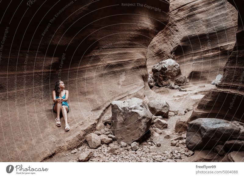 Young woman hiking on a rock canyon young girl blue barranco vacas cave volcanic spain copy space geological travel geology erosion nature tour tourism