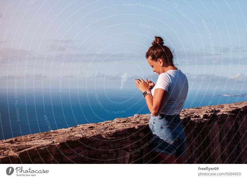 Digital nomad working on her phone while on a viewpoint woman smartphone nature digital communication copy space mobile message mobile phone lifestyle