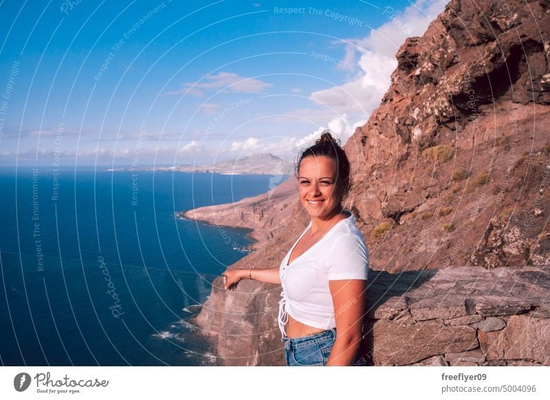 Woman looking the ocean from a viewpoint portrait young woman nature copy space blue tourist hiking travel gran canaria canary islands spain bow atlantic sea