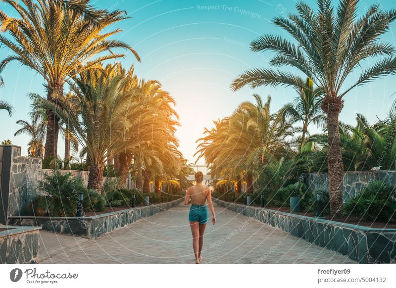 Tourist walking through Gran Canaria Palm walks woman palms lifestyle luxury tropical summer beach caribbean people travel happy vacation fun 20s nature coastal