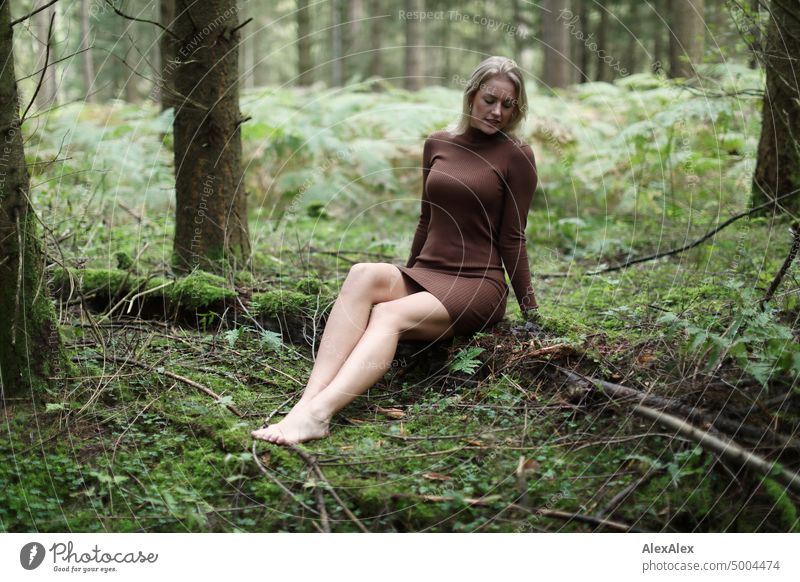 Young blonde woman sitting barefoot on fallen log in forest Young woman Woman Blonde Feminine pretty fortunate Youth (Young adults) portrait Adults naturally