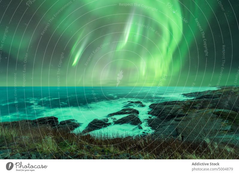 Bright northern lights over North Sea polar night sea bright rocky coast nature landscape colorful arctic island seashore aurora borealis phenomenon cold